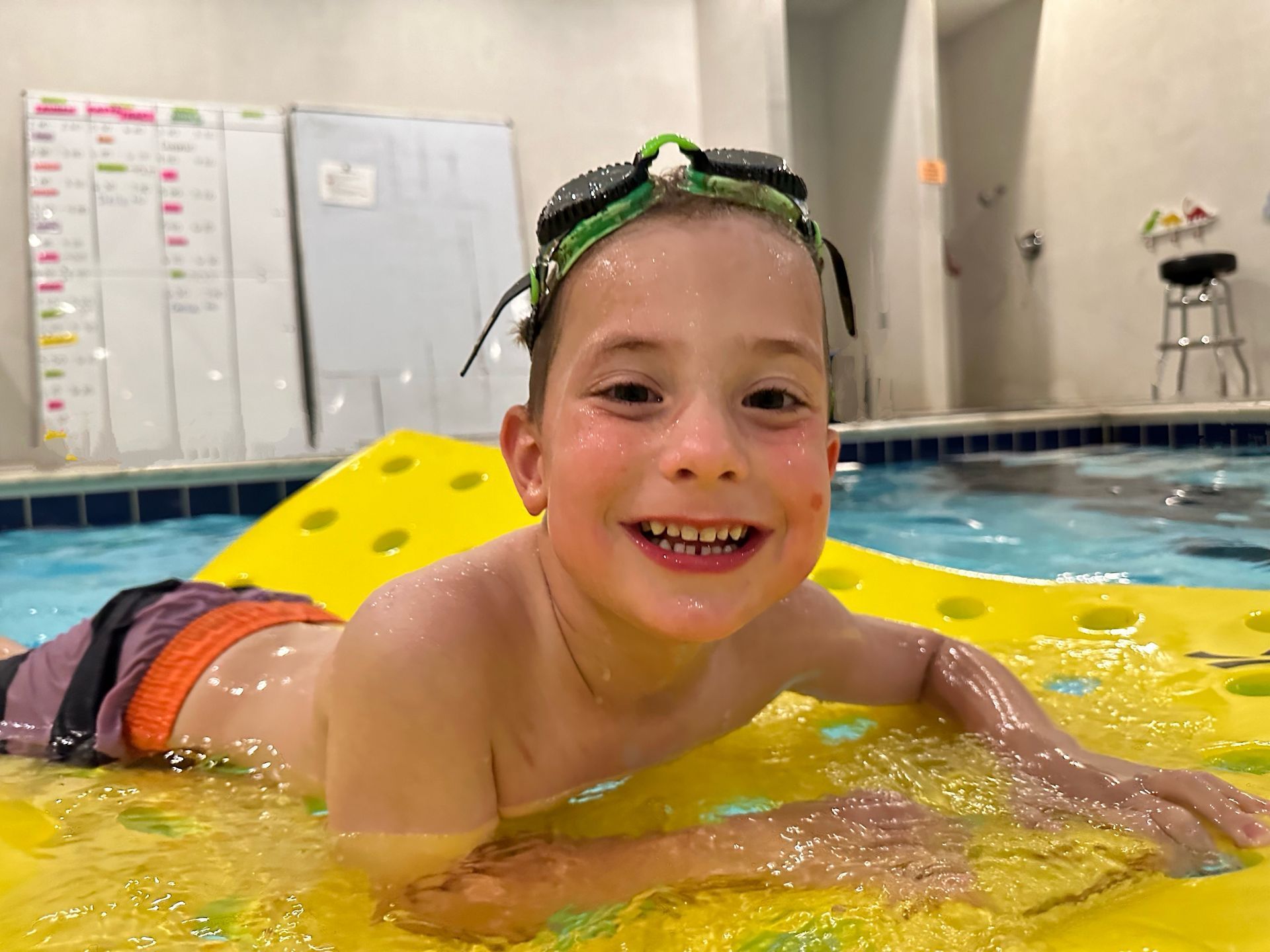 A child learning to swim with an instructor